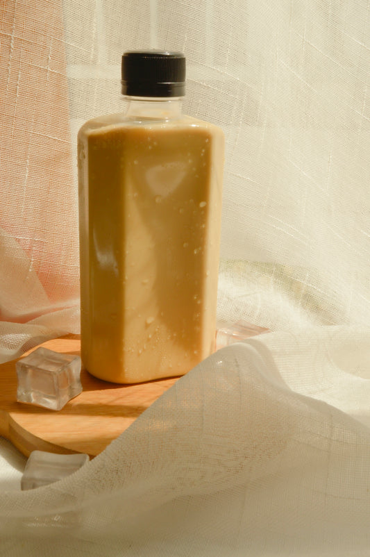 A bottle of liquid sitting on top of a wooden cutting board