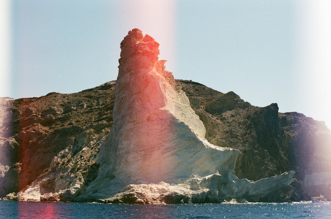 A lighthouse on a small island in the middle of the ocean