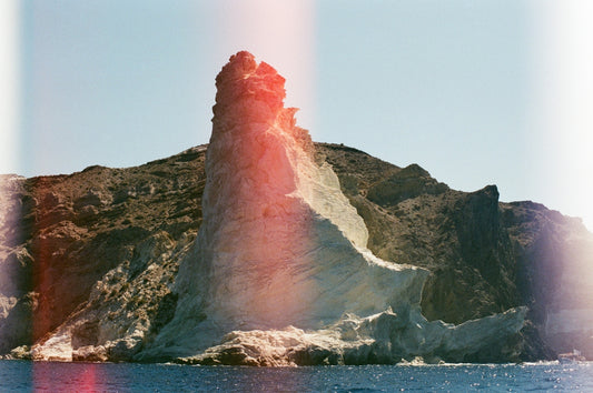 A lighthouse on a small island in the middle of the ocean